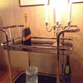 Serveringsvagn från Trendrum. På vagnen en champagneflaska, två glas och en kandelaber.m Butler 7 - Drinkvagn (svart)